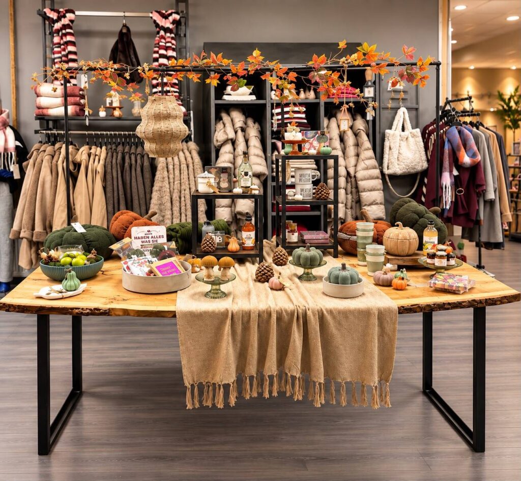 Großer Holztisch mit Herbstdeko, Kürbissen und Accessoires in der Boutique HerzDame